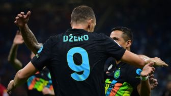 Pemain depan Inter Milan Edin Dzeko (kanan) menendang bola dan mencetak gol selama pertandingan sepak bola Serie A Italia antara Inter Milan melawan Bologna di Stadion Giuseppe Meazza, Sabtu waktu setempat atau Minggu (19/9/2021) dini hari WIB. MIGUEL MEDINA / AFP
