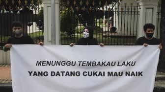 Massa yang tergabung dalam masyarakat pertembakauan membentangkan spanduk saat menggelar aksi unjuk rasa di luar Istana Merdeka, Jakarta, Senin (20/9/2021). [Suara.com/Angga Budhiyanto]