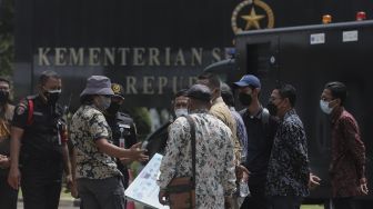 Perwakilan massa aksi masyarakat pertembakauan berdiskusi dengan petugas keamanan saat menggelar aksi unjuk rasa di luar Istana Merdeka, Jakarta, Senin (20/9/2021). [Suara.com/Angga Budhiyanto]