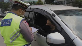 Polisi melakukan penindakan terhadap pengendara yang melanggar lalu lintas saat Operasi Patuh Jaya 2021 di kawasan Bundaran Hotel Indonesia, Jakarta, Senin (20/9/2021). [Suara.com/Angga Budhiyanto]