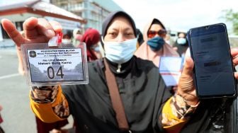 Peziarah menunjukkan aplikasi PeduliLindungi serta tanda izin masuk di depan Pos Pemeriksaan Kawasan Wisata Makam Presiden Soekarno di Kota Blitar, Jawa Timur, Selasa (21/9/2021). ANTARA FOTO/Irfan Anshori
