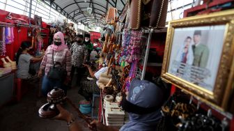 
Pedagang cinderamata menawarkan dagangannya kepada para peziarah yang melintas di Pasar Wisata Makam Presiden Soekarno di Kota Blitar, Jawa Timur, Selasa (21/9/2021). ANTARA FOTO/Irfan Anshori