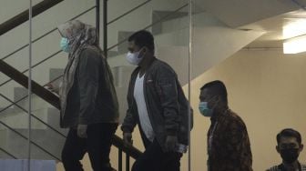 Bupati Kolaka Timur Andi Merya Nur (kiri) berjalan menuju ruang pemeriksaan di Gedung Merah Putih KPK, Jakarta, Rabu (22/9/2021) malam. [Suara.com/Angga Budhiyanto]