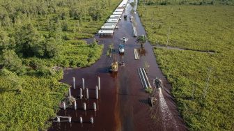 Foto udara pengendara mobil berusaha menerobos banjir yang merendam di jalan trans Kalimantan Bukit Rawi, Pulang Pisau, Kalimantan Tengah, Kamis (23/9/2021).  ANTARA FOTO/Makna Zaezar