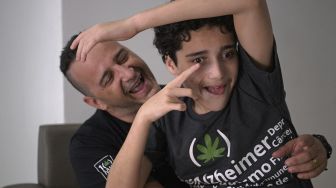 Gabriel Guerra (kanan) bersama ayahnya, Ricardo Guerra berpose di Rio de Janeiro, Brasil, pada (20/9/2021). [Carl de Souza / AFP]