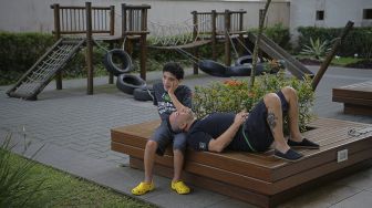 Gabriel Guerra (kiri), yang menderita autisme parah dan lumpuh otak (cerebral palsy), berfoto bersama ayahnya Ricardo Guerra di Rio de Janeiro, Brasil, pada (20/9/2021). [Carl de Souza / AFP]