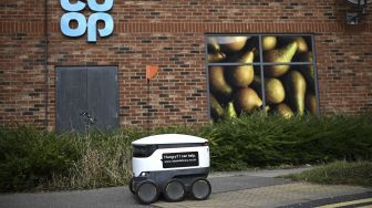 Sebuah robot otonom bernama Starship mengantarkan bahan makanan dari supermarket Co-op di Milton Keynes, Inggris, pada (20/9/2021). [DANIEL LEAL-OLIVAS / AFP]