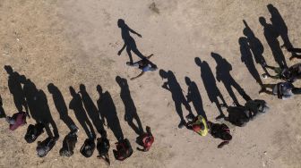 Foto udara migran Haiti mengantre untuk menerima makanan di tempat penampungan di Ciudad Acuna, negara bagian Coahuila, Meksiko, pada (23/9/2021). [PEDRO PARDO / AFP]