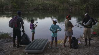 Migran Haiti mencari tempat untuk menyeberangi sungai Rio Grande menuju Amerika Serikat di Ciudad Acuna, negara bagian Coahuila, Meksiko, pada (23/9/2021). [PEDRO PARDO / AFP]