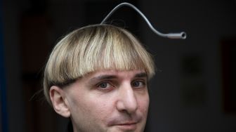 Artis cyborg Inggris-Irlandia dan aktivis transpesi Neil Harbisson, berpose di Mataro, Barcelona, Spanyol, pada (23/9/2021). [Josep LAGO / AFP]