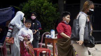 Sejumlah anak didampingi orang tuanya bergegas usai mengikuti sunatan massal yang digelar di Binong Permai, Kabupaten Tangerang, Banten, Sabtu (25/9/2021). [Suara.com/ Hilal Rauda Fiqry]