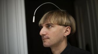 Artis cyborg Inggris-Irlandia dan aktivis transpesi Neil Harbisson, berpose di Mataro, Barcelona, Spanyol, pada (23/9/2021). [Josep LAGO / AFP]