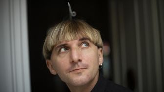 Artis cyborg Inggris-Irlandia dan aktivis transpesi Neil Harbisson, berpose di Mataro, Barcelona, Spanyol, pada (23/9/2021). [Josep LAGO / AFP]