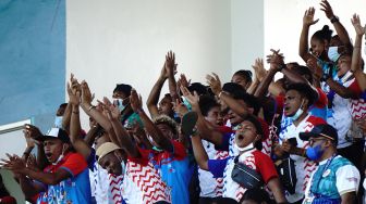 Suporter tim kriket putra Papua memberikan dukungan saat pertandingan semifinal kriket PON Papua antara tim kriket putra Papua melawan tim kriket putra Jawa Barat, di Stadion Kriket, Doyo Baru, Kabupaten Jayapura, Papua, Minggu (26/9/2021). ANTARA FOTO/Indrayadi TH