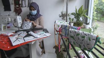 Perajin membuat produksi tas dari kantong plastik bekas di Anda Craft, Sawangan, Depok, Jawa Barat, Minggu (26/9/2021).  ANTARA FOTO/Asprilla Dwi Adha
