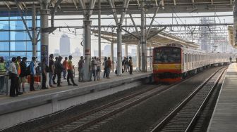 Penumpang menunggu kereta Commuterline di Jalur Layang Bogor Line Stasiun Manggarai, Jakarta Selatan, Minggu (26/9/2021). [Suara.com/Alfian Winanto]