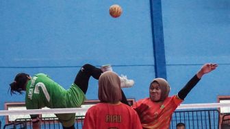 Atlet sepak takraw putri Jawa Timur Jawa Timur Avlia Febriani (kiri) menangkis smes dari atlet sepak takraw putri Riau Nurhidayah (kanan) dalam pertandingan sepak takraw ganda putri PON Papua, di GOR Trikora Universitas Cenderawasih, Jayapura, Papua, Senin (27/9/2021).  ANTARA FOTO/Indrayadi TH