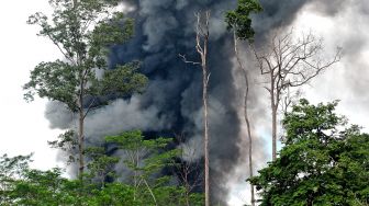 Asap mengepul dari sumur minyak ilegal yang terbakar di Bungku, Bajubang, Batanghari, Jambi, Senin (27/9/2021). ANTARA FOTO/Wahdi Septiawan