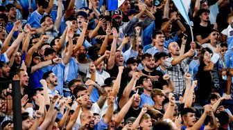 Suporter Lazio melakukan selebrasi usai pertandingan sepak bola Serie A Italia Lazio melawan AS Roma  di Stadion Olimpico, Senin (27/9/2021) dini hari WIB
Vincenzo PINTO / AFP