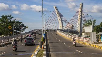 Sejumlah pengendara motor melintas di bawah Jembatan Sungai Alalak, Banjarmasin, Kalimantan Selatan, Rabu (29/9/2021).  ANTARA FOTO/Bayu Pratama 
