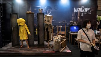 Para aktor bermain di stan video game "Little Nightmares II" selama Tokyo Game Show di Prefektur Chiba, Jepang, pada (30/9/2021). [CHARLY TRIBALLEAU / AFP]