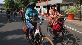 Anggota komunitas sepeda tua Senopati berpakaian batik mengayuh sepedanya di Jalan Darmo, Surabaya, Jawa Timur, Minggu (3/10/2021). ANTARA FOTO/Didik Suhartono