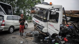 Sopir truk berada di depan kabin truk yang mengalami kecelakaan di kilometer 134 Jalan Tol Purbaleunyi, Pasir Koja, Bandung, Jawa Barat, Minggu (3/10/2021). ANTARA FOTO/Raisan Al Farisi