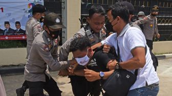 Sejumlah anggota polisi mengamankan pendemo saat membubarkan aksi unjuk rasa memprotes ketimpangan pembangunan di Banten yang berlangsung di depan Gedung DPRD Banten di Serang, Senin (4/10/2021).  ANTARA FOTO/Asep Fathulrahman