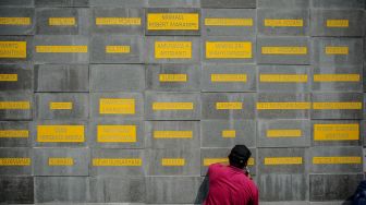 Pekerja memahat nama dari tenaga kesehatan yang gugur akibat COVID-19 di Monumen Gasibu, Bandung, Jawa Barat, Senin (4/10/2021).  ANTARA FOTO/Raisan Al Farisi