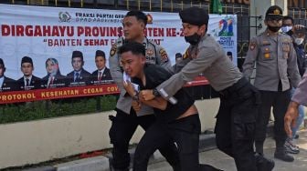 Sejumlah anggota polisi mengamankan pendemo saat membubarkan aksi unjuk rasa memprotes ketimpangan pembangunan di Banten yang berlangsung di depan Gedung DPRD Banten di Serang, Senin (4/10/2021).  ANTARA FOTO/Asep Fathulrahman