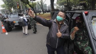 Warga berswafoto bersama prajurit TNI saat pameran alutsista di depan Istana Merdeka, Jakarta, Senin (4/10/2021). [Suara.com/Angga Budhiyanto]