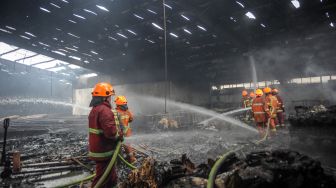 Petugas pemadam kebakaran melakukan pendinginan di sebuah pabrik tekstil yang terbakar di Cijerah, Bandung, Jawa Barat, Senin (4/10/2021). ANTARA FOTO/Raisan Al Farisi
