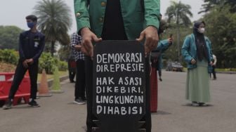 Massa yang tergabung dalam Badan Eksekutif Mahasiswa Seluruh Indonesia (BEM SI) melakukan aksi simbolik di kawasan Patung Kuda Arjuna Wiwaha, Jakarta, Rabu (6/10/2021). [Suara.com/Angga Budhiyanto]