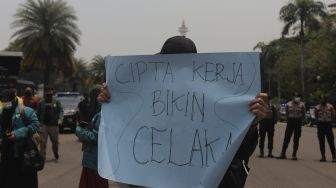 Massa yang tergabung dalam Badan Eksekutif Mahasiswa Seluruh Indonesia (BEM SI) membawa poster saat melakukan aksi simbolik di kawasan Patung Kuda Arjuna Wiwaha, Jakarta, Rabu (6/10/2021). [Suara.com/Angga Budhyanto]