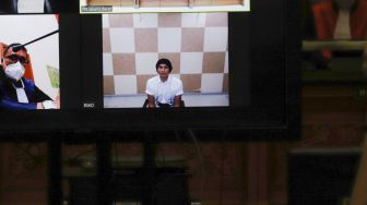 Musisi Erdian Aji Prihartanto atau Anji saat menjalani sidang secara virtual di Pengadilan Negeri Jakart Barat, Rabu (6/10/2021). [Suara.com/Alfian Winanto]