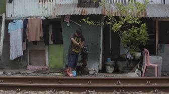 Seorang anak memompa air tanah di kawasan Petamburan, Jakarta, Rabu (6/10/2021). [Suara.com/Angga Budhiyanto]