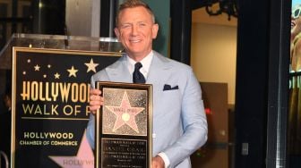 Daniel Craig berpose dengan replika bintang barunya di Hollywood Walk of Frame saat penghargaan di Los Angeles, Rabu (6/10). VALERIE MACON / AFP