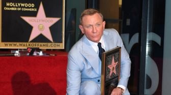 Daniel Craig berpose dengan replika bintang barunya di Hollywood Walk of Frame saat penghargaan di Los Angeles, Rabu (6/10). VALERIE MACON / AFP