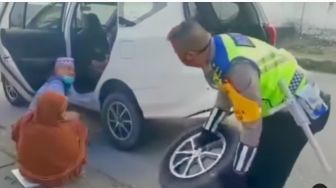 Viral Aksi Polisi Bantu Kakek Nenek Pengendara Mobil yang Alami Pecah Ban, Publik Salut