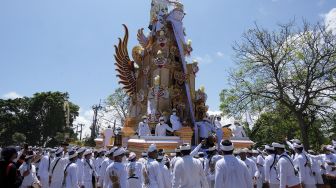 Ratusan warga mengiringi arak-arakan bade atau menara usungan jenazah Ida Pedanda Nabe Gede Dwija Ngenjung saat upacara Ngaben di kawasan Sanur, Denpasar, Bali, Jumat (8/10/2021). [ANTARA FOTO/Nyoman Hendra Wibowo]