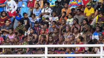 Warga menyaksikan pertandingan tim sepak bola putri Papua melawan tim sepak bola putri Babel pada semifinal Sepak Bola Putri PON Papua di Stadion Katalpal, Kabupaten Merauke, Papua, Sabtu (9/10/2021). [ANTARA FOTO/Galih Pradipta]