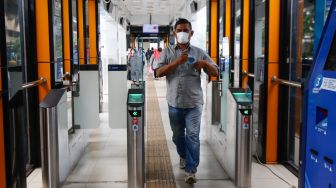 Penumpang menggunakan kartu JakLingko di Halte Tosari, Jakarta Pusat, Minggu (10/10/2021). [Suara.com/Alfian Winanto]