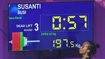 Lifter Jawa Barat Susi Susanti bersiap melakukan angkatan dead lift saat berlaga dalam nomor angkat berat 52kg putri PON Papua di Jayapura, Papua, Senin (11/10/2021).  ANTARA FOTO/Akbar Nugroho Gumay
