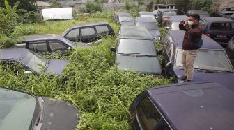 Jurnalis televisi mengambil gambar puluhan mobil dinas Pemkot Tangerang yang terbengkalai di Tangerang, Banten, Selasa (12/10/2021).  ANTARA FOTO/Muhammad Iqbal