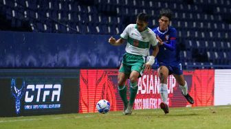 Pesepak bola Indonesia Rachmat Irianto (kiri) berebut bola dengan pesepak bola Taiwan Lin Ming-Wei pada leg kedua Play-off Kualifikasi Piala Asia 2023 di Stadion Chang Arena Buriram, Thailand, Senin (11/10/2021).  ANTARA FOTO