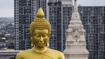 Patung Buddha raksasa setinggi 69 meter berdiri di kuil Wat Paknam Phasi Charoen, Bangkok, pada (12/10/2021). [JACK TAYLOR / AFP]