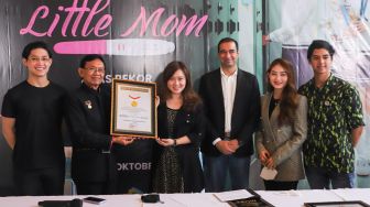 Direktur Operasional Museum Rekor Indonesia (MURI), Yusuf Ngadri (kedua kiri) saat memberikan piagam MURI kepada drama web series Little Mom yang berhasil memecahkan rekor di Hitmakers Studio, Jakarta Pusat, Rabu (13/10/2021). [Suara.com/Alfian Winanto]