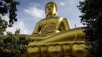 Patung Buddha raksasa setinggi 69 meter berdiri di kuil Wat Paknam Phasi Charoen, Bangkok, pada (12/10/2021). [JACK TAYLOR / AFP]