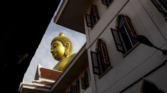 Patung Buddha raksasa setinggi 69 meter berdiri di kuil Wat Paknam Phasi Charoen, Bangkok, pada (12/10/2021). [JACK TAYLOR / AFP]