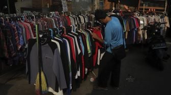 Calon pembeli memilih pakaian bekas layak pakai (thrifting) yang dijual di Pasar Kebayoran Lama, Jakarta, Rabu (13/10/2021). [Suara.com/Angga Budhiyanto]